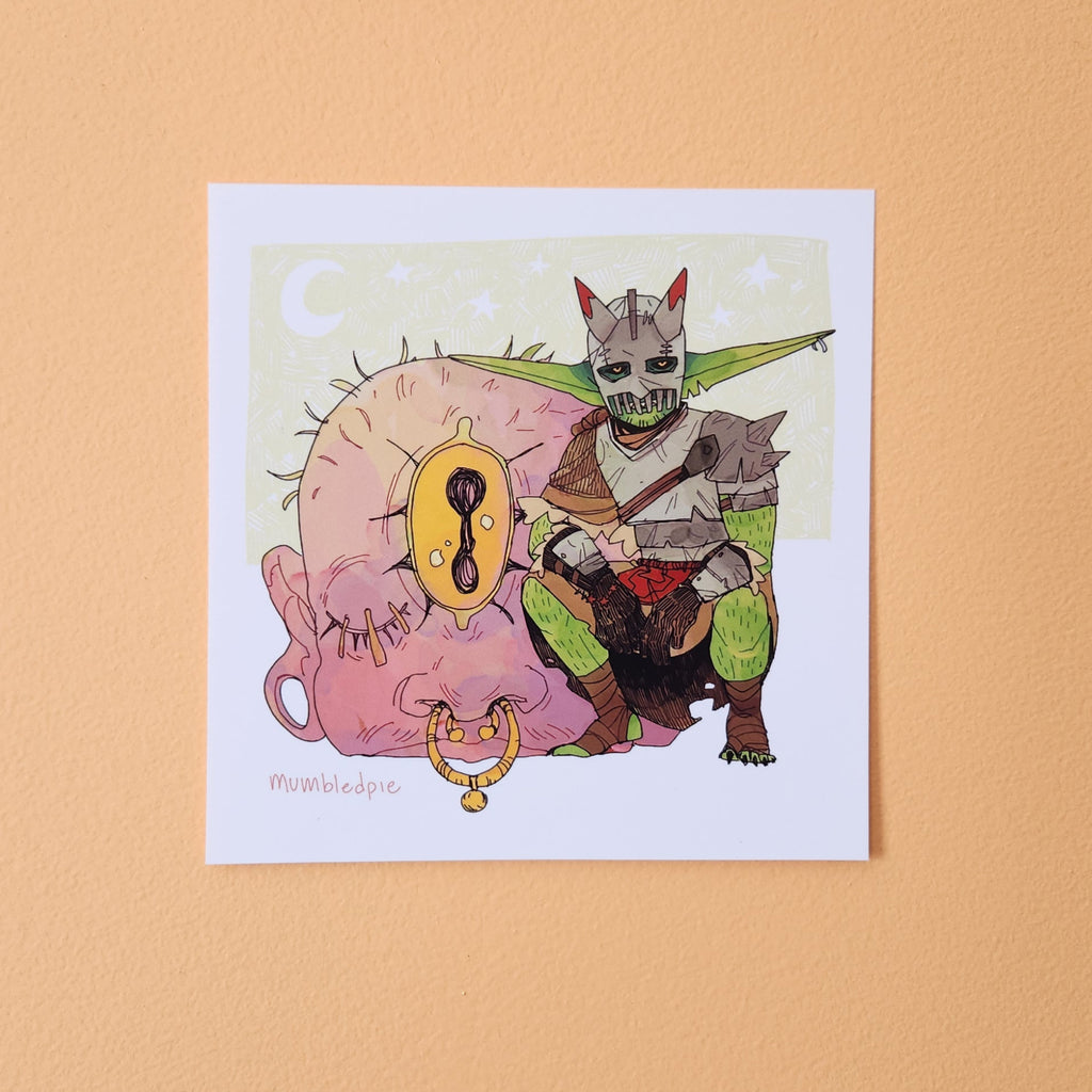 A square art print featuring a whimsical illustration of a green-skinned fantasy Goblin with horns and a mask, posed over a large pink cyclops.