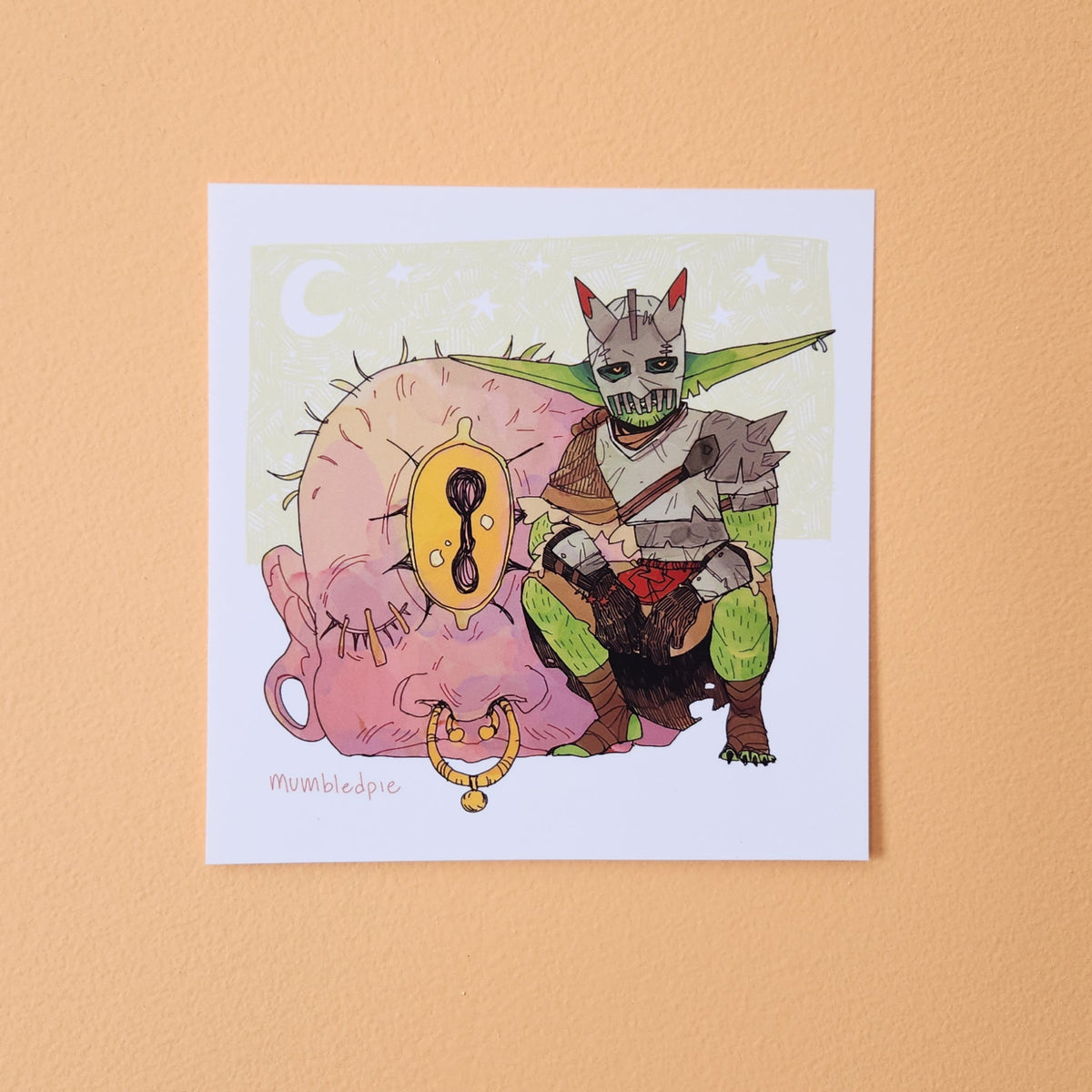 A square art print featuring a whimsical illustration of a green-skinned fantasy Goblin with horns and a mask, posed over a large pink cyclops.
